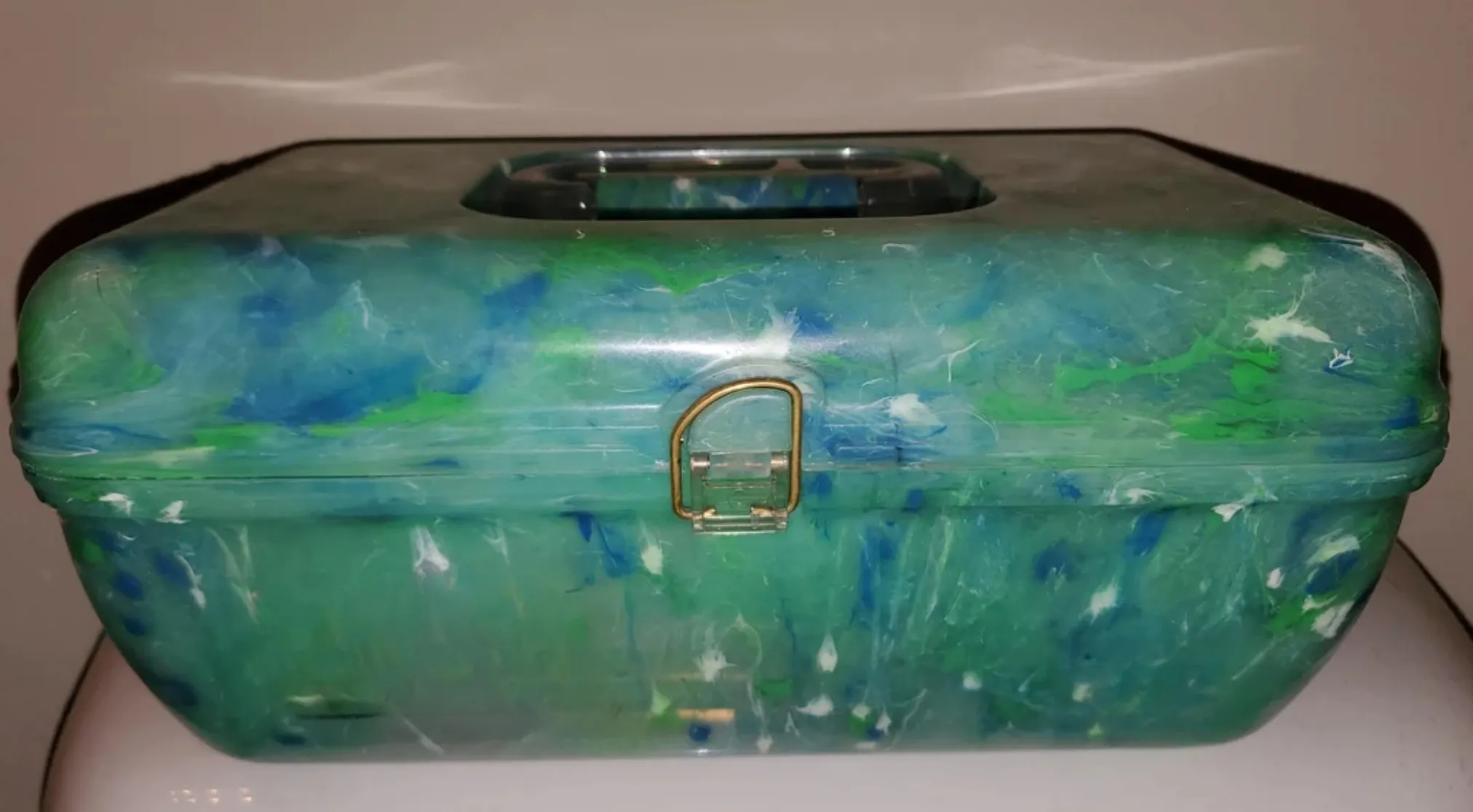 Vintage item: a marbled green and blue plastic box with a handle and gold latch. Guess what this is called.