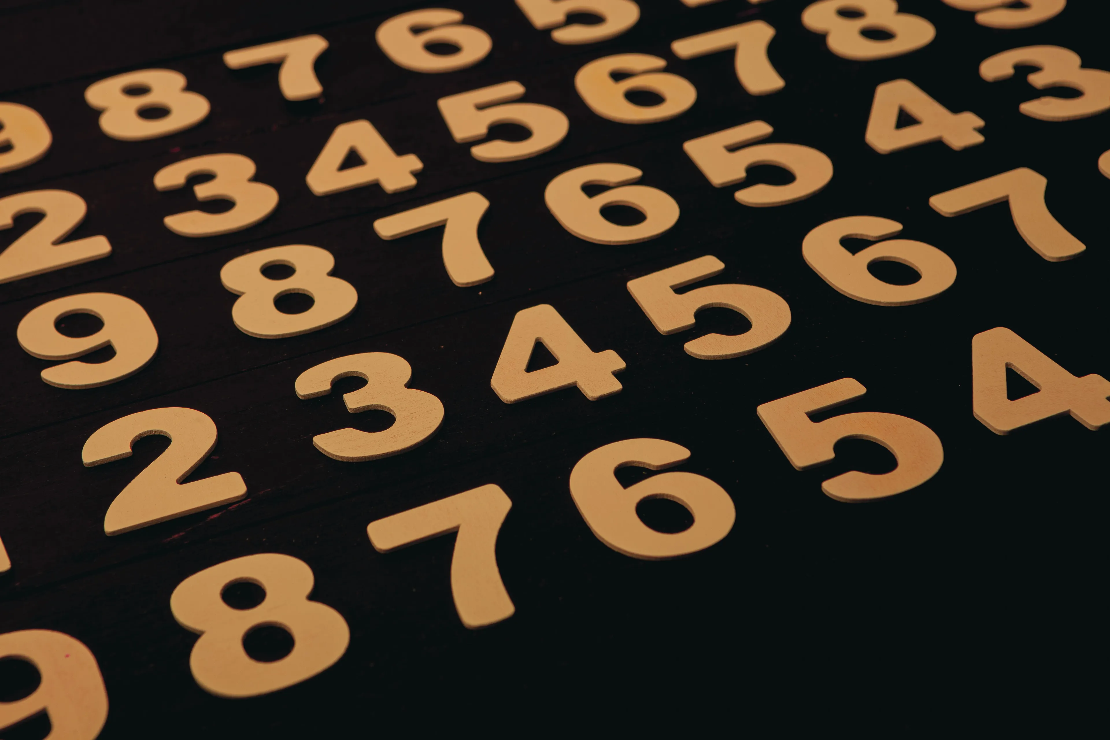 Wooden numbers 1 through 9 arranged on a dark surface, symbolizing a Japanese Cube Personality Type quiz.