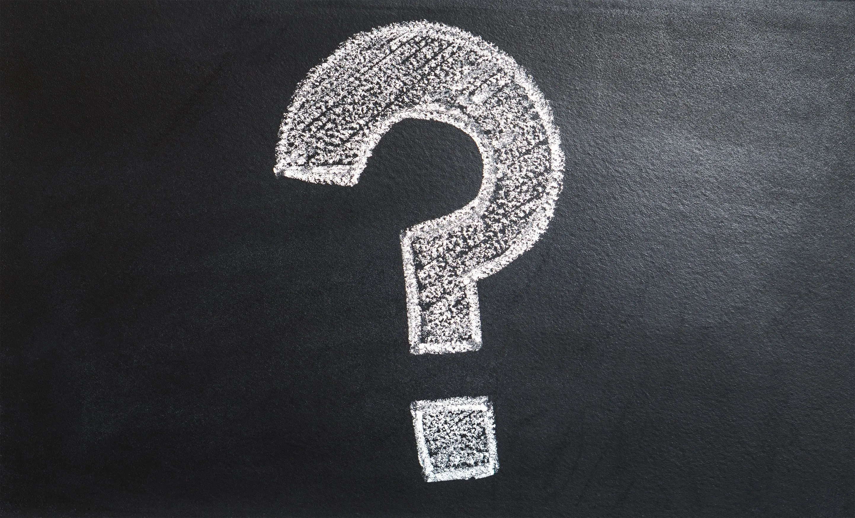 A question mark drawn in white chalk on a black chalkboard, representing uncertainty or a personality type quiz.