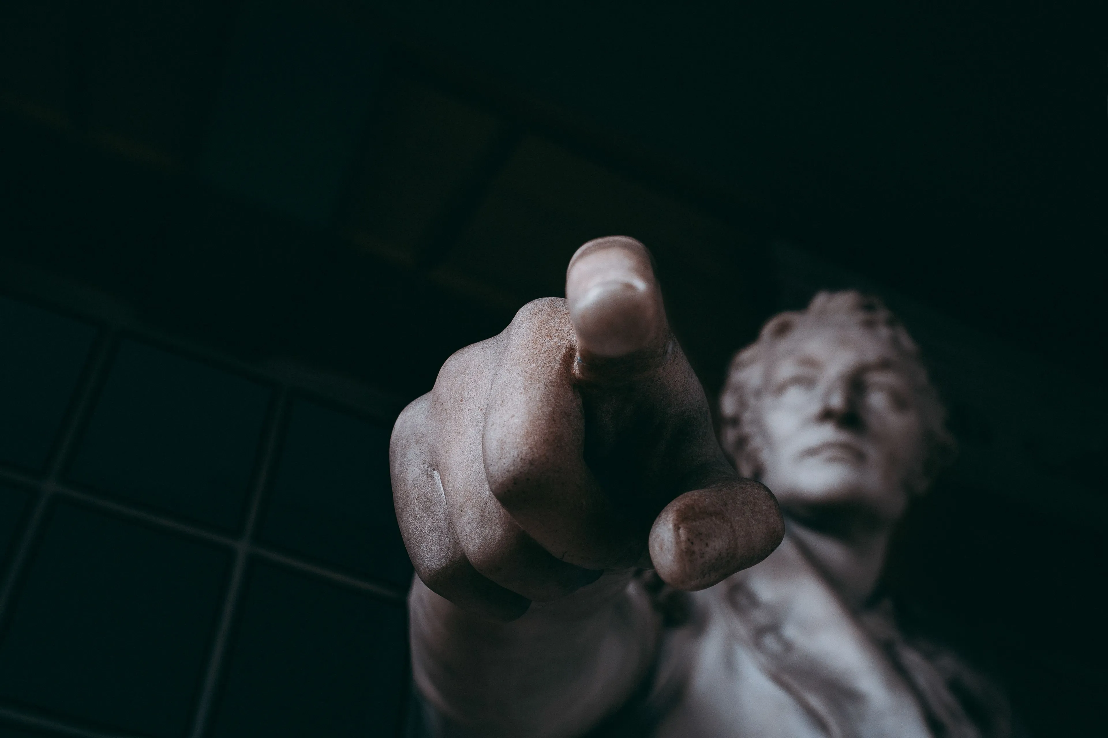 A close-up of a statue's hand pointing forward, with the face blurred in the background, implying focus. What's your Japanese Cube Personality Type?