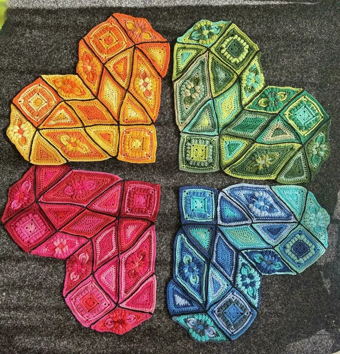 Colorful crochet hearts arranged on dark background