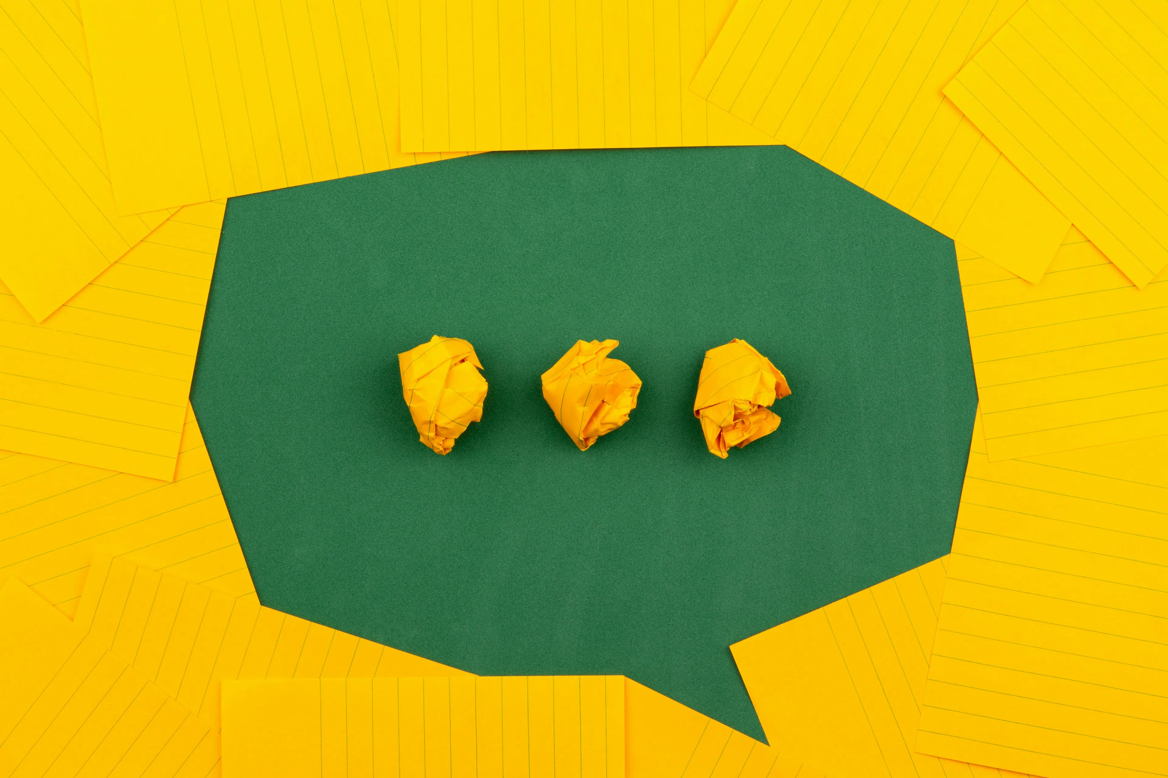 A green speech bubble surrounded by yellow sticky notes, symbolizing language family questions for a general knowledge test for high IQs.