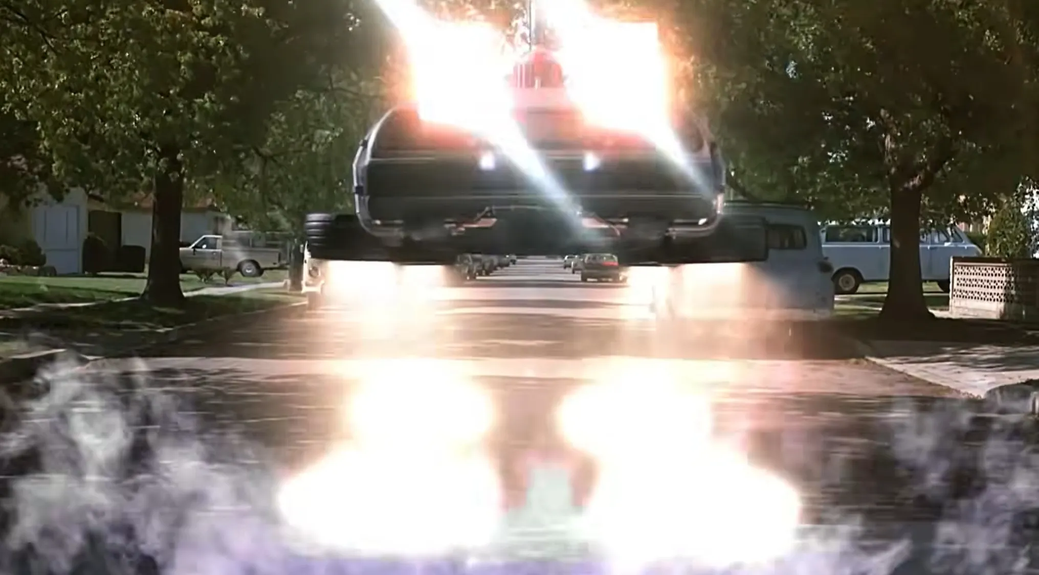 The DeLorean time machine takes off into the sky in a bright, fiery ending scene from a film.