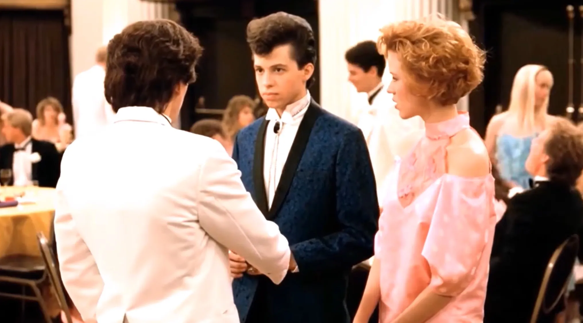 This ending scene shows three people at a formal event, with the man in the blue suit looking forward.