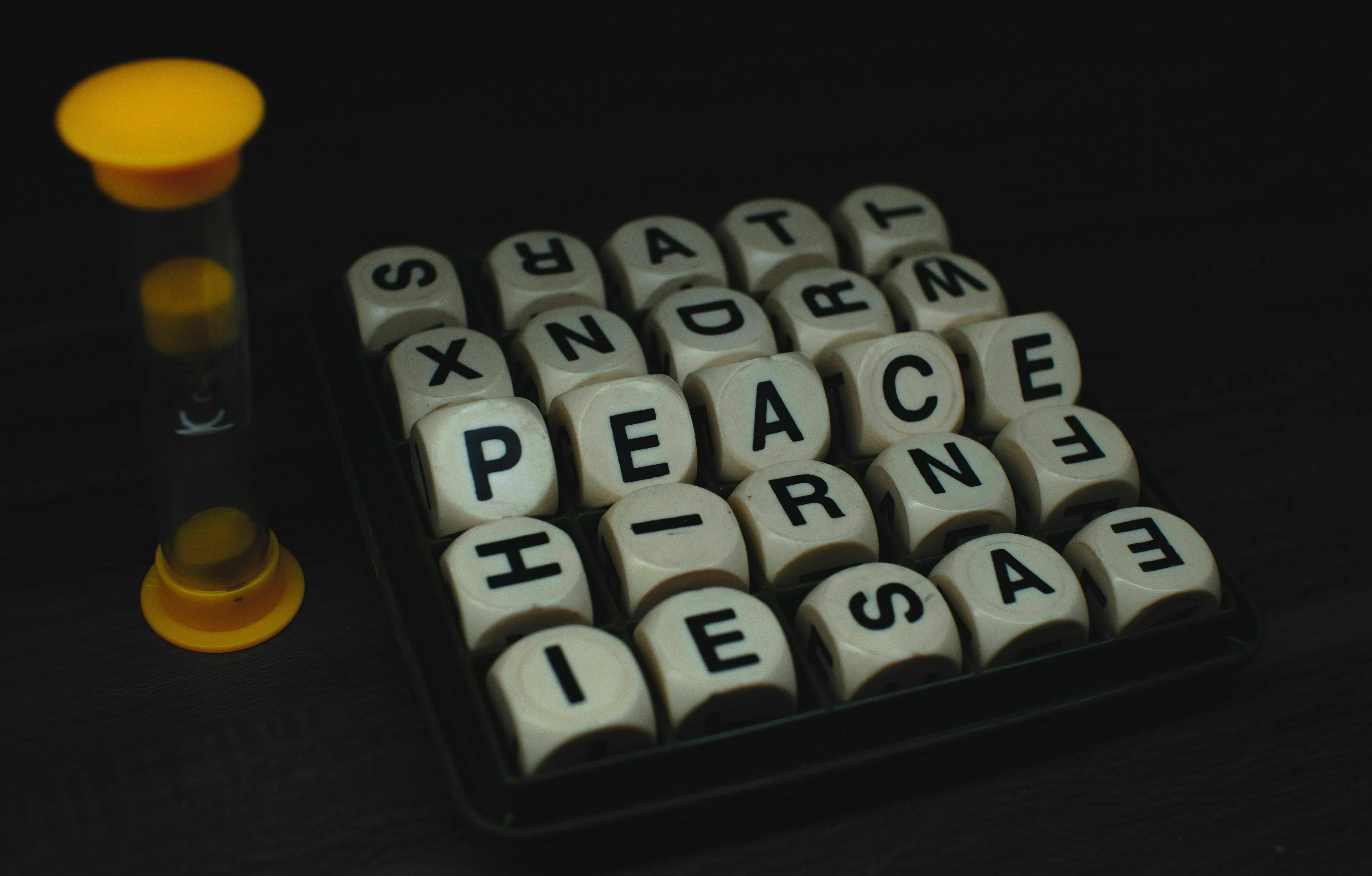 A mythological trickster approaches a riddle, symbolized by letter dice spelling out PEACE and a timer.