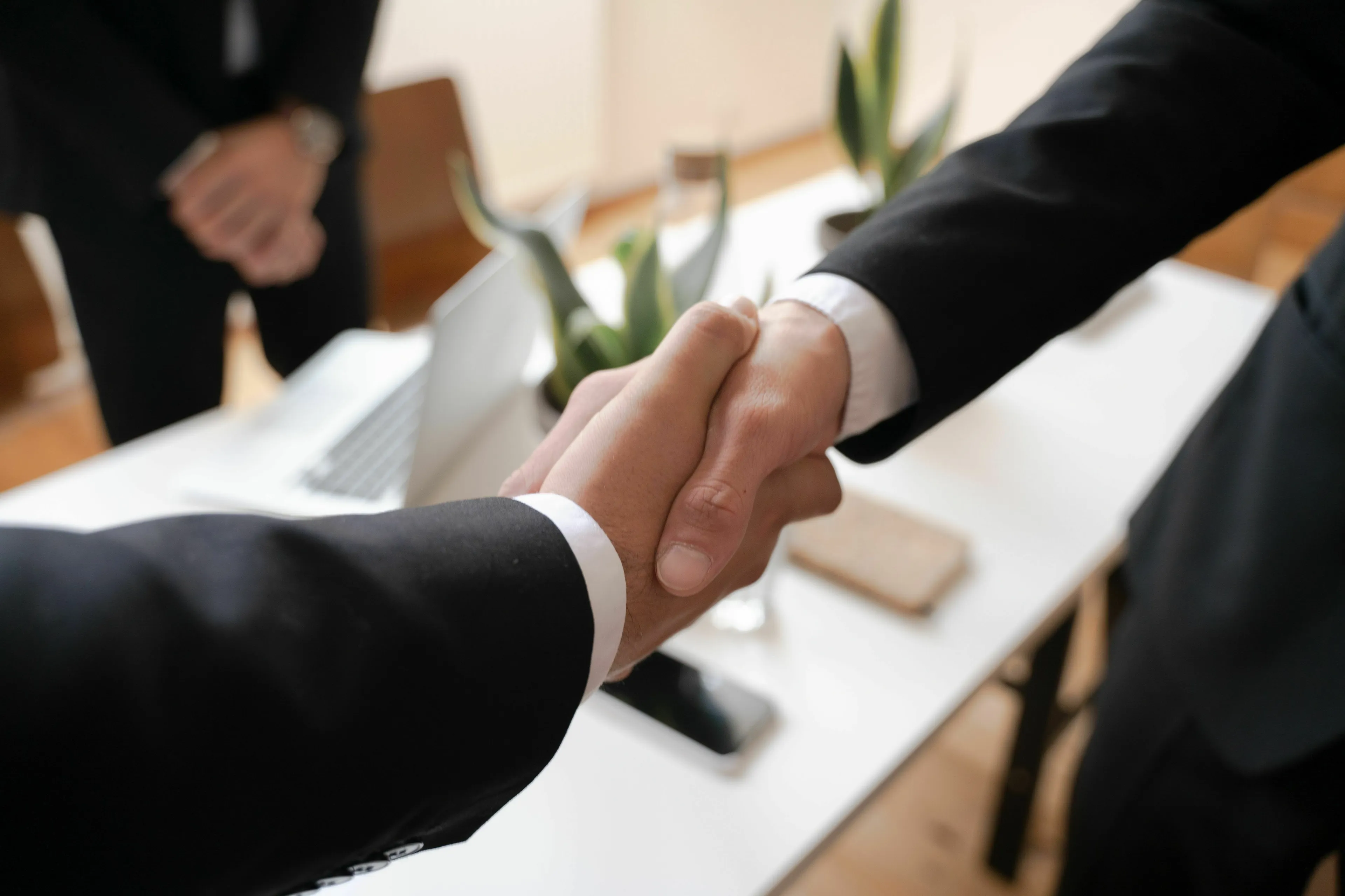 A mythological trickster responds to a too-good deal, symbolized by two businessmen shaking hands.