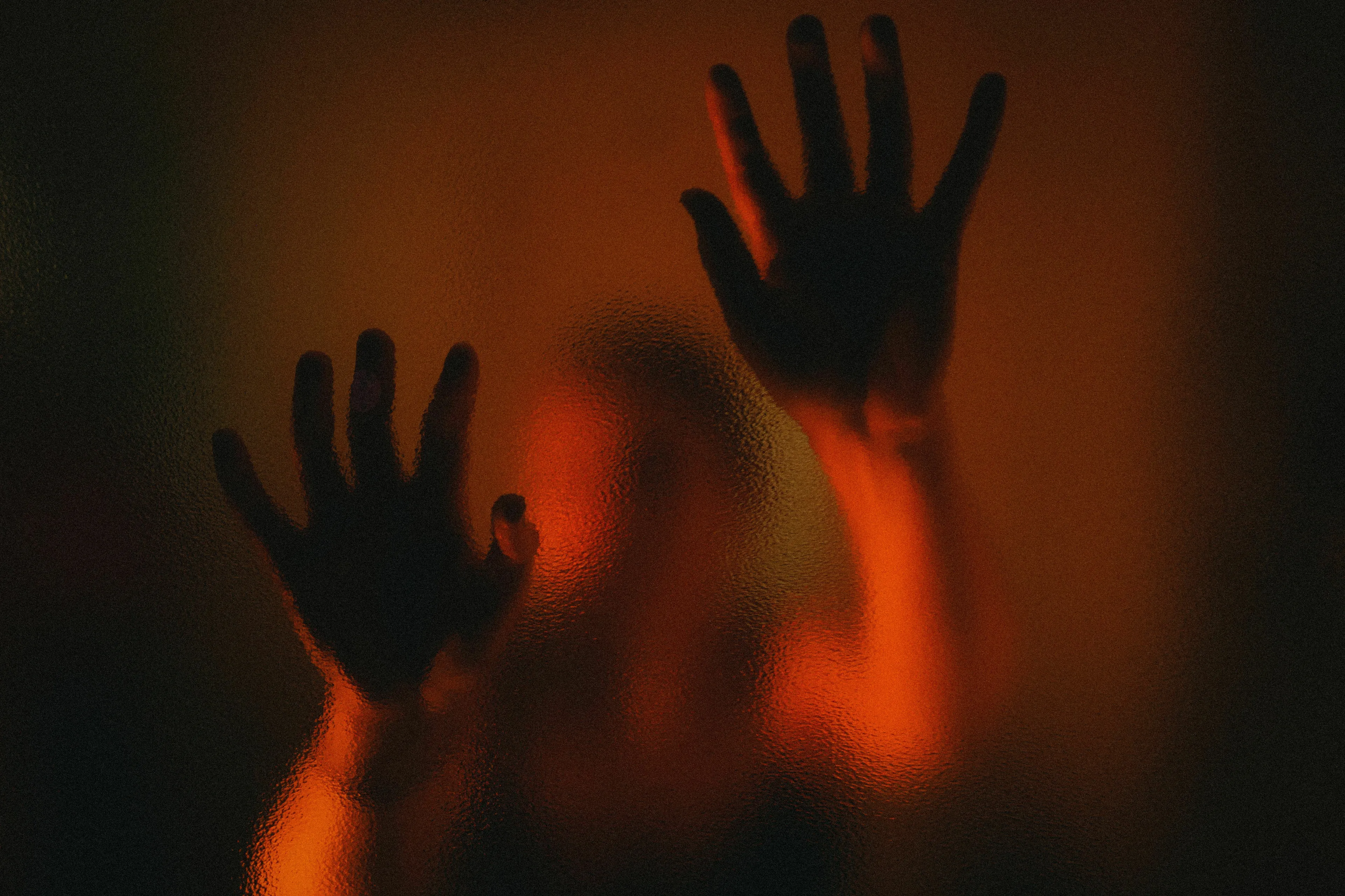 A mythological trickster instinctively reacts to being trapped, symbolized by blurred hands pressed against glass.