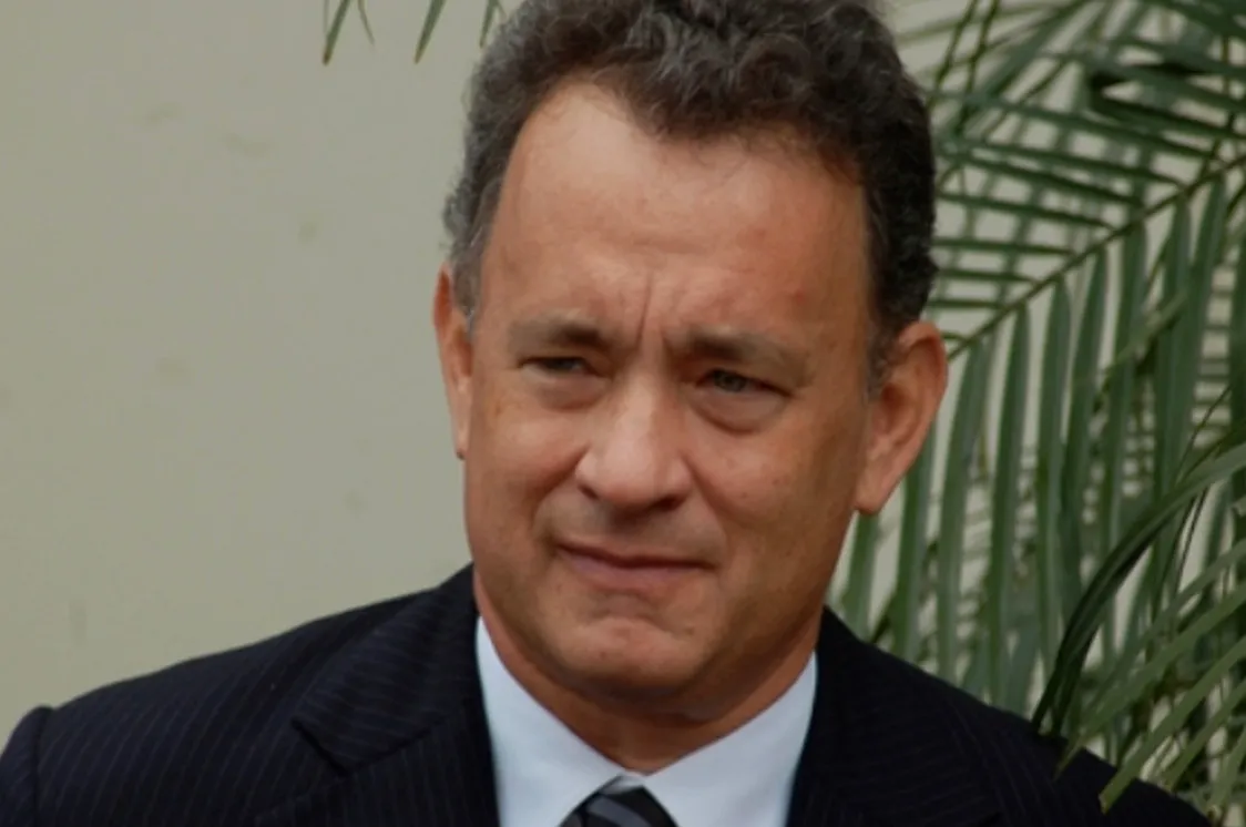 Close-up of actor Tom Hanks in a suit, with a blurred green background, for a General Knowledge Quiz.