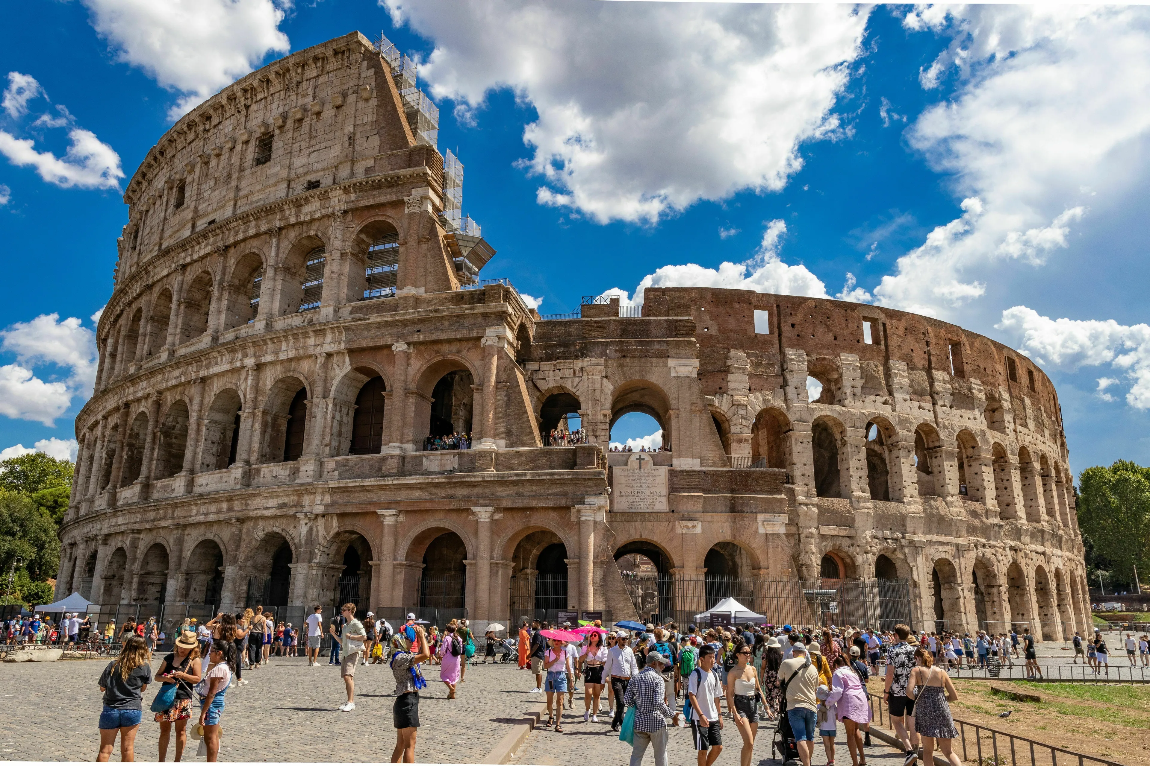 The Colosseum in Rome, an ancient civilisation structure, with many tourists around on a sunny day for a General Knowledge Quiz.