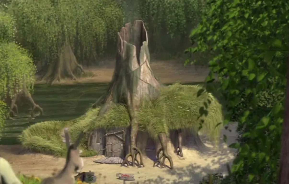 Shrek's swamp home, a tree-like house with grass growing on its roof, in a lush green swamp.