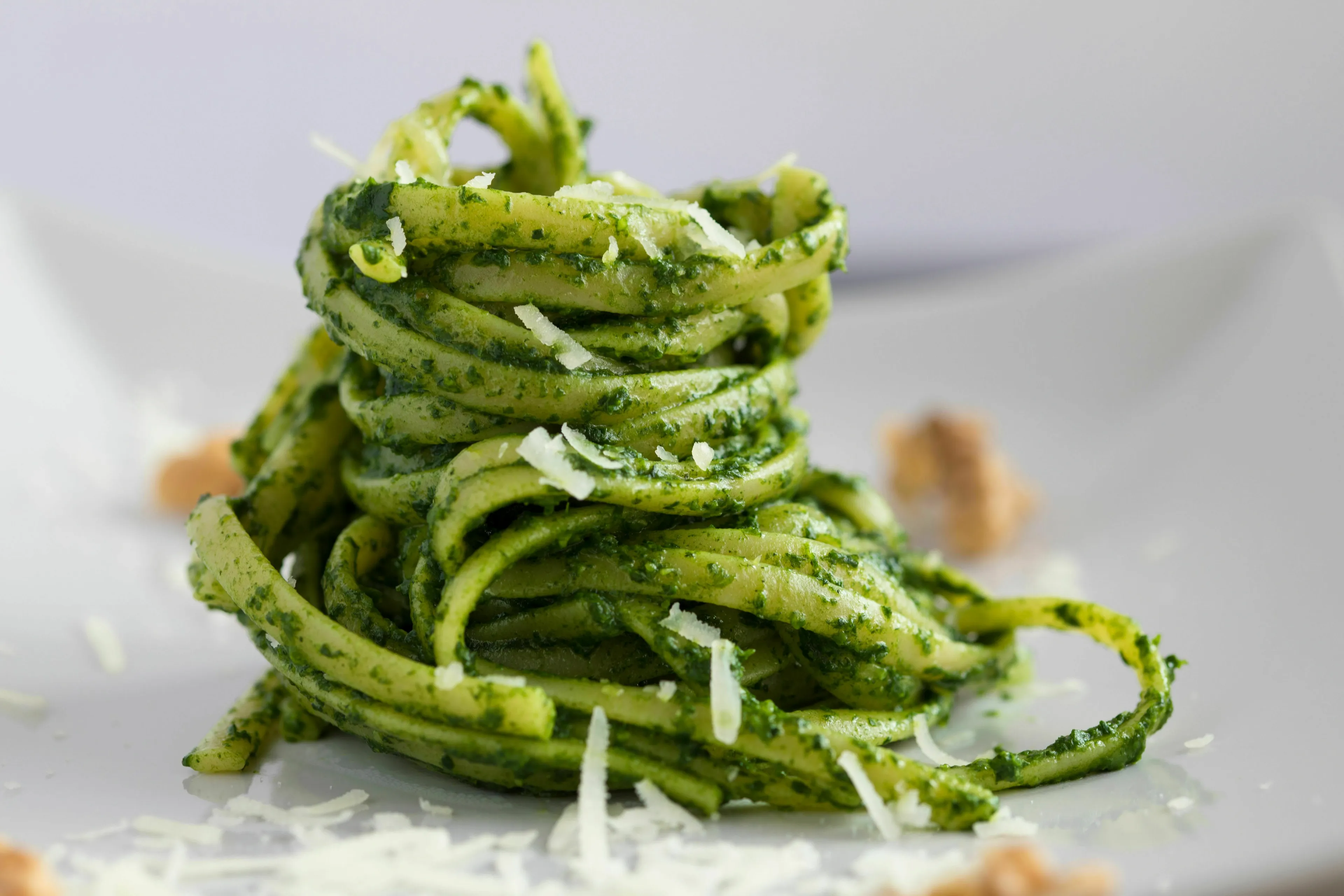 Delicious green pesto pasta dish, showcasing the traditional herb used to make green pesto.