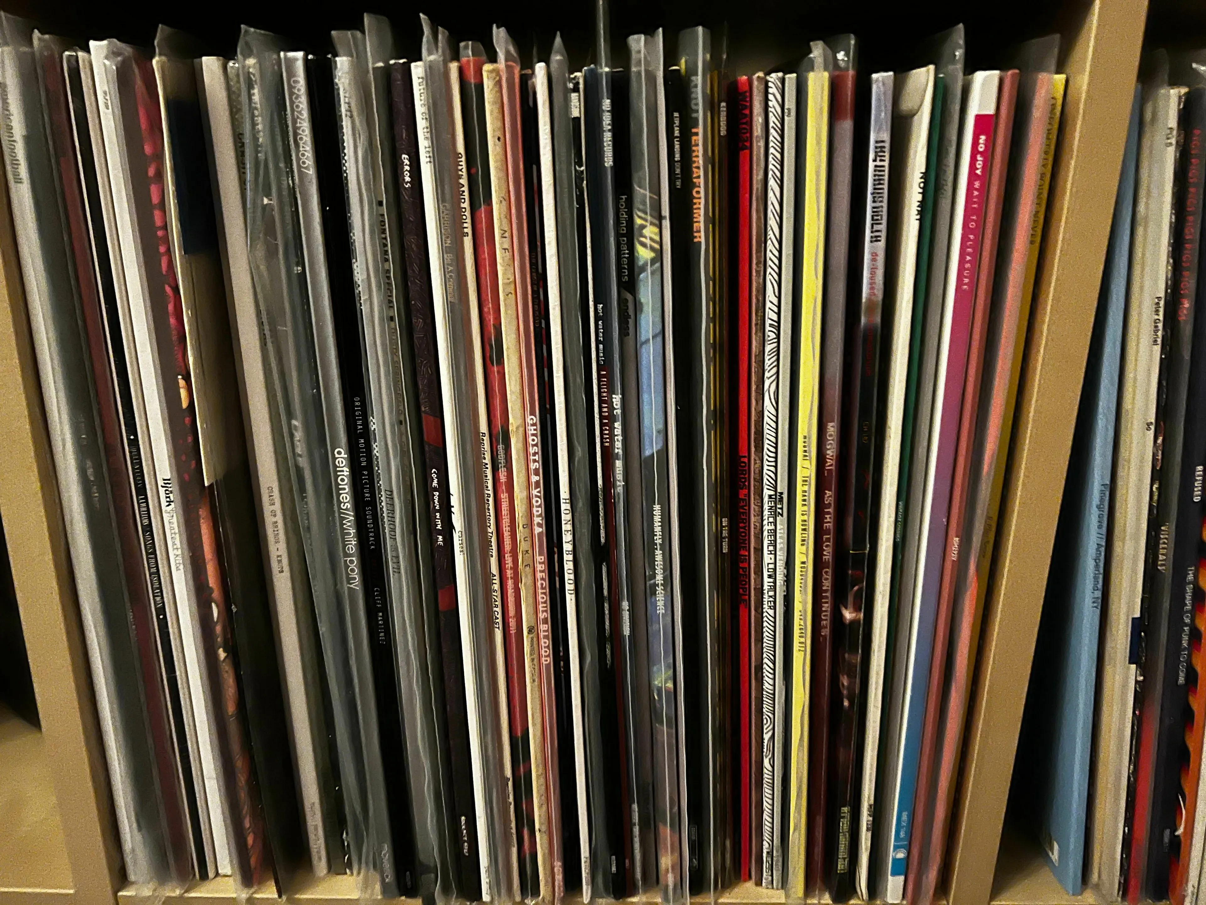 A collection of vinyl records, including albums 19, 21, and 25, stands neatly on a shelf.
