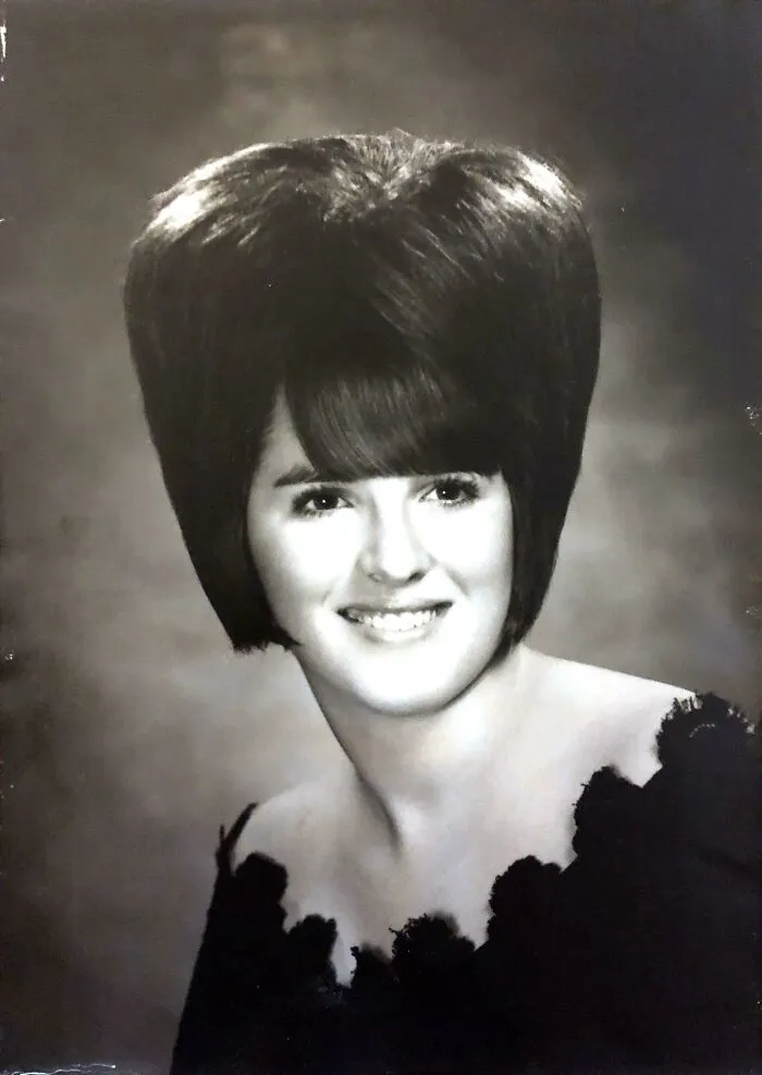 Black and white portrait of a woman with a towering, voluminous hairstyle, showcasing bold hairstyles.