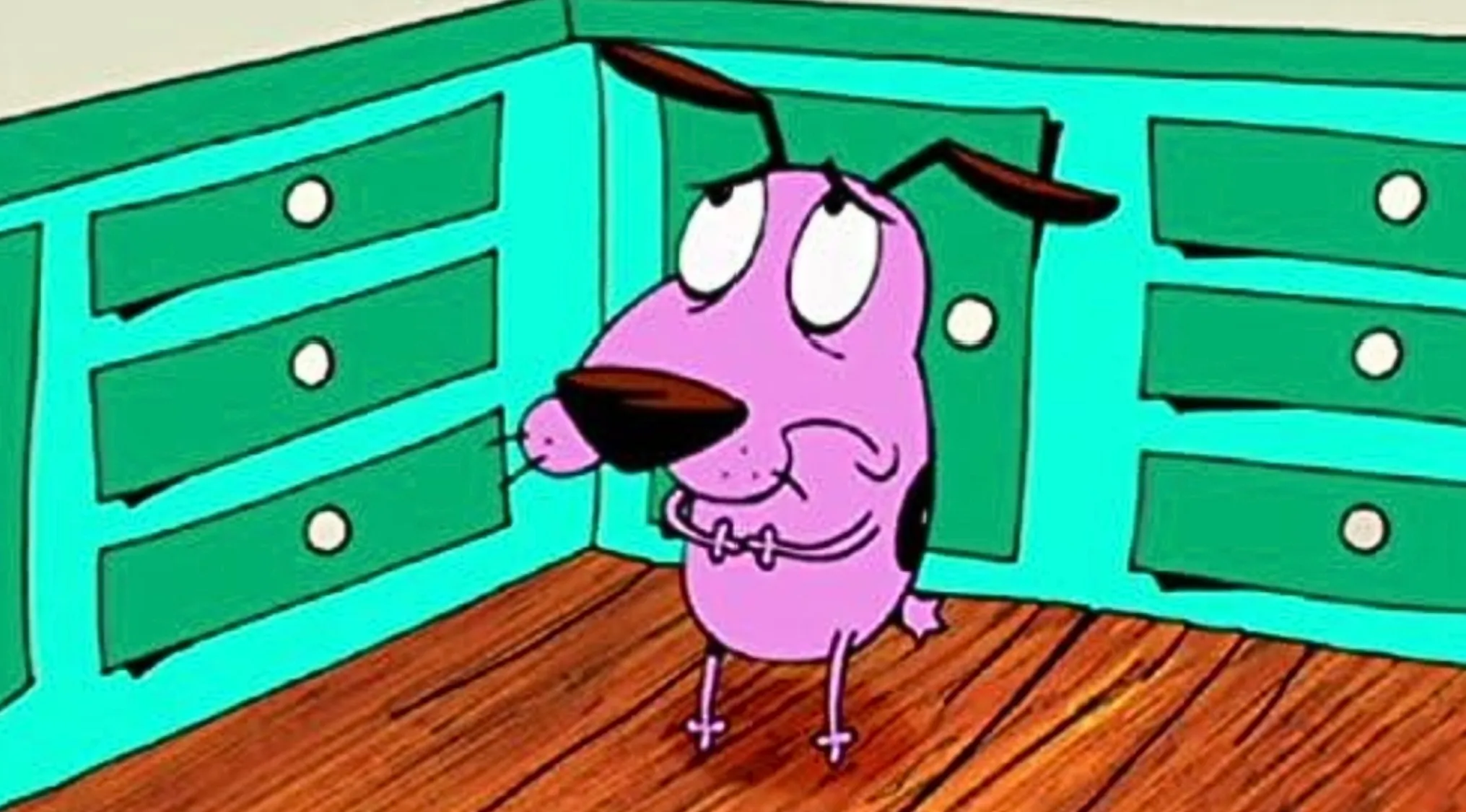 Courage the Cowardly Dog, a cartoon character, looks distressed in a kitchen with green cabinets.