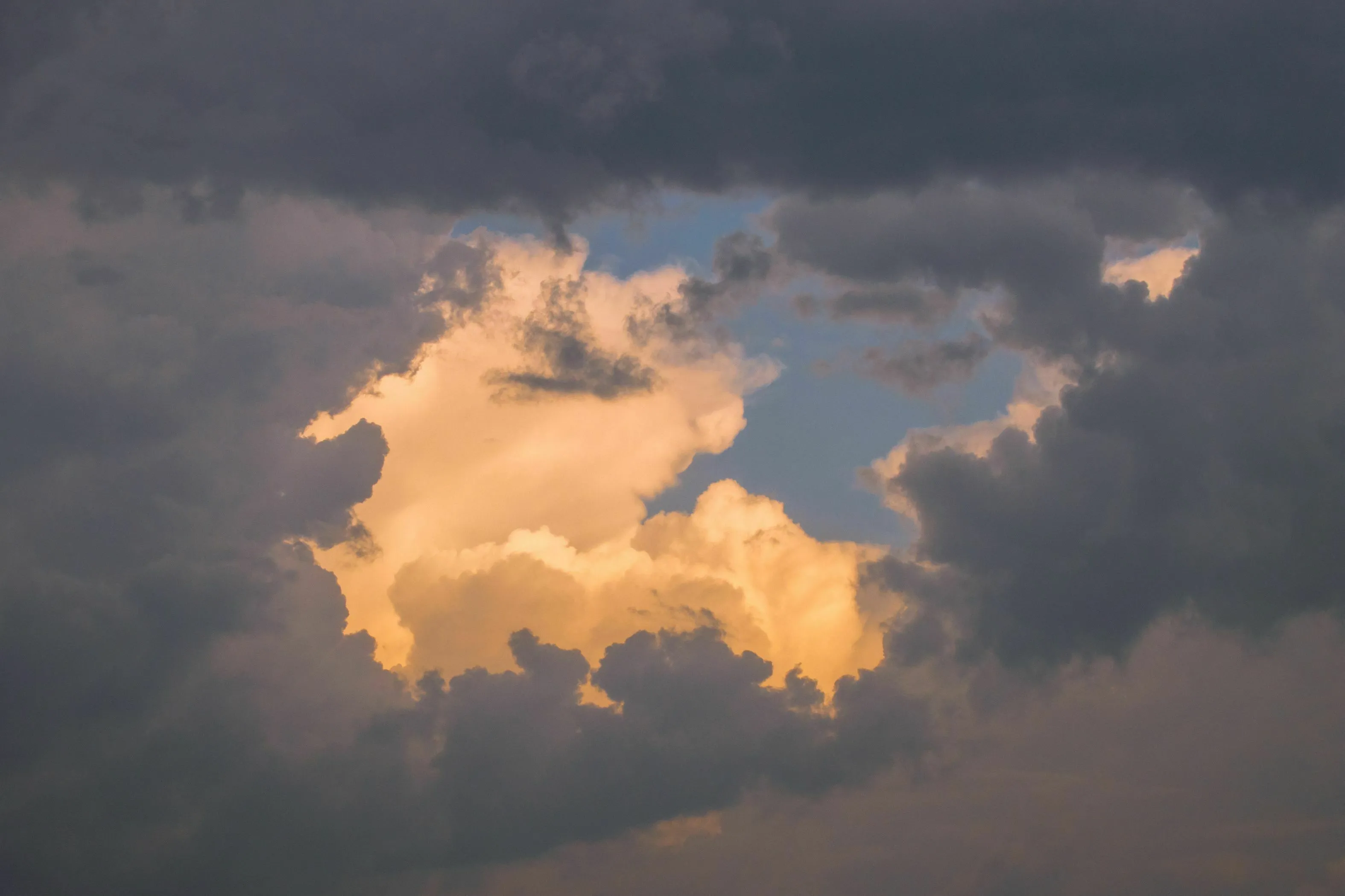 Dark clouds with a bright, light-filled opening in the center, representing an angel number message.