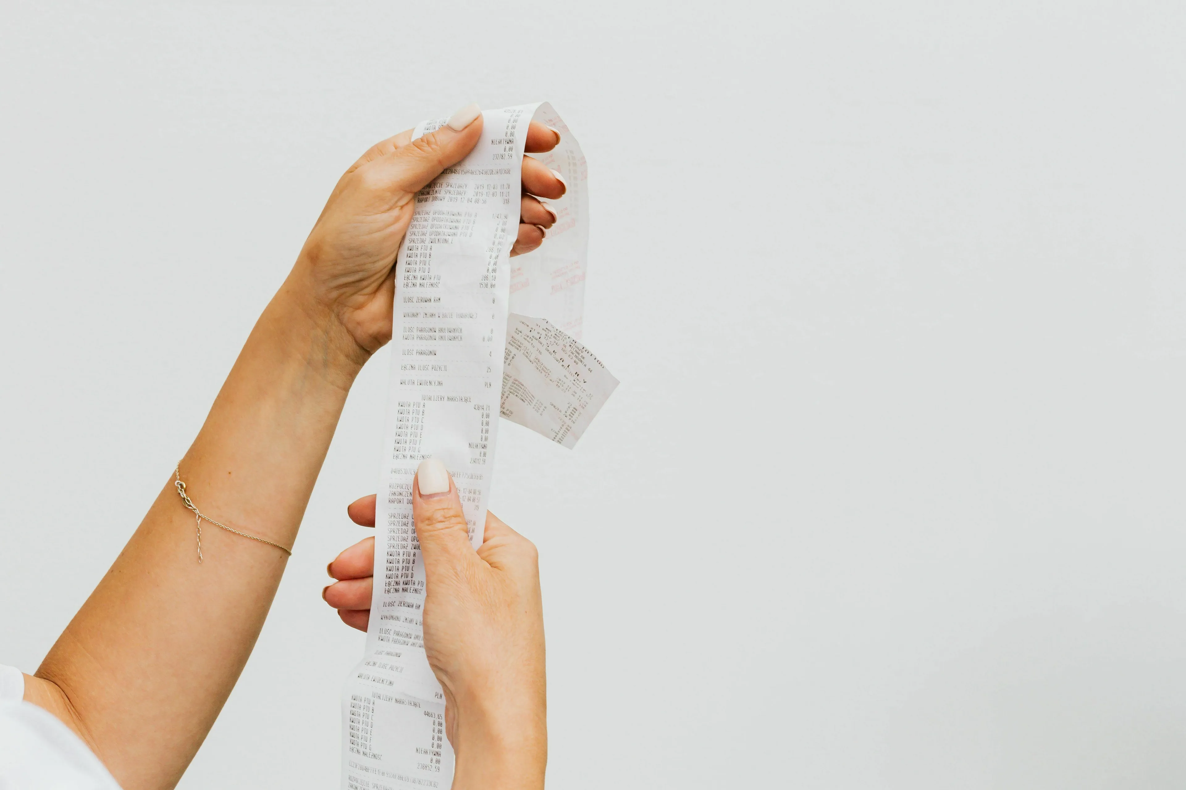 Hands holding a long receipt, a common way to discover an angel number.