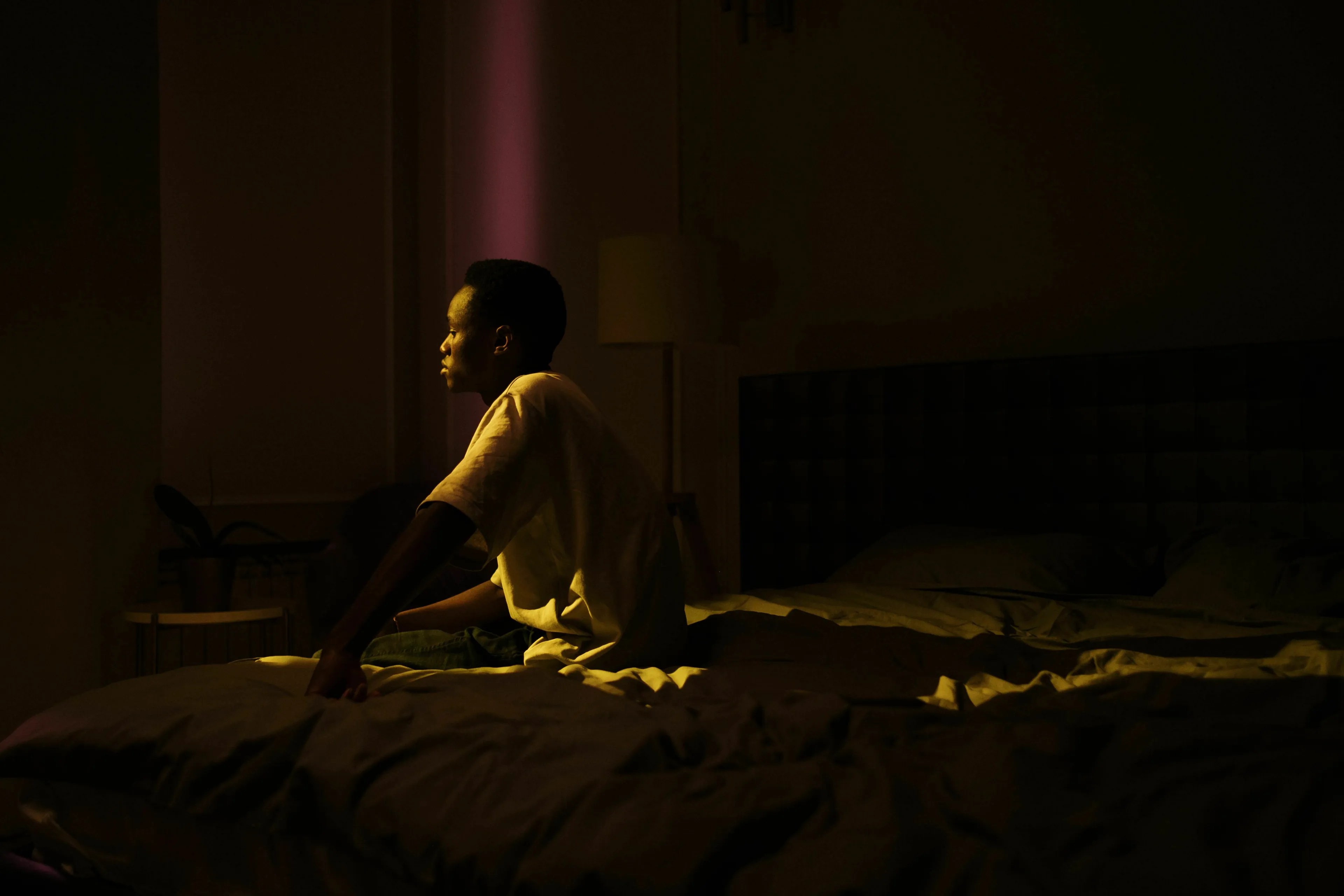 A person awake in bed in the dark, contemplating an angel number at 3 AM.