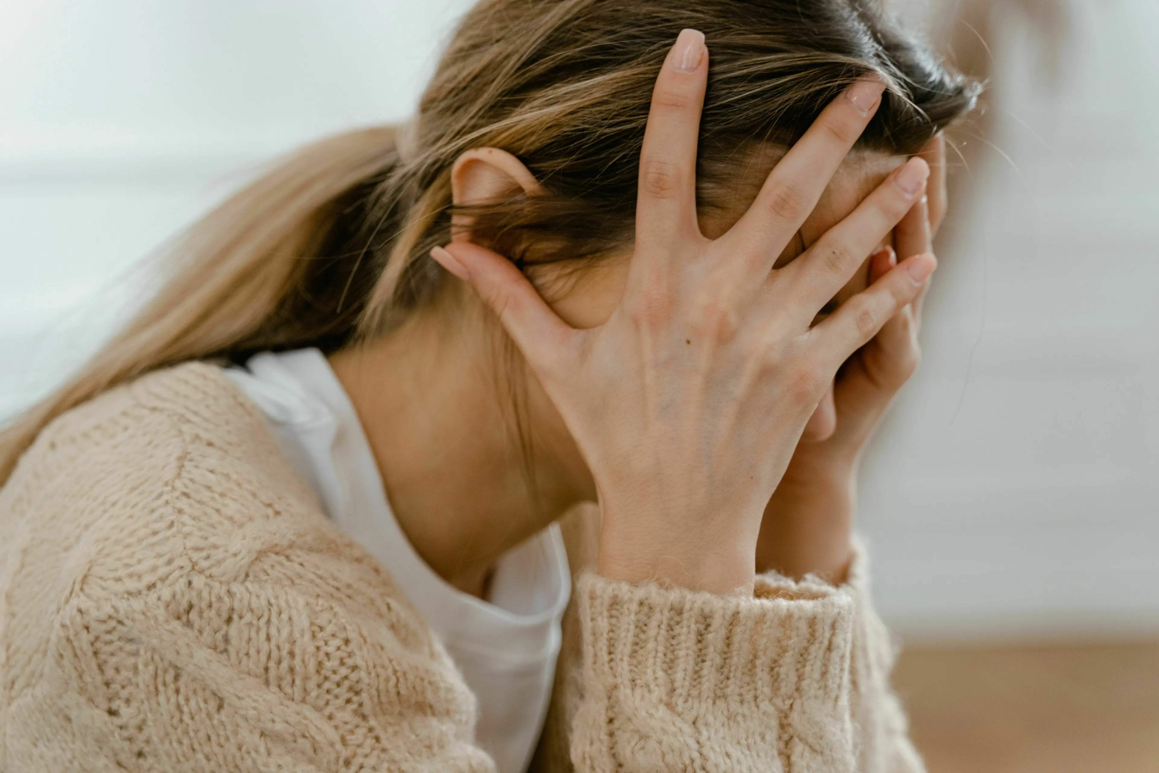 A woman with her face in her hands, looking nervous. What's Your Angel Number? What do you do before something you're nervous about?