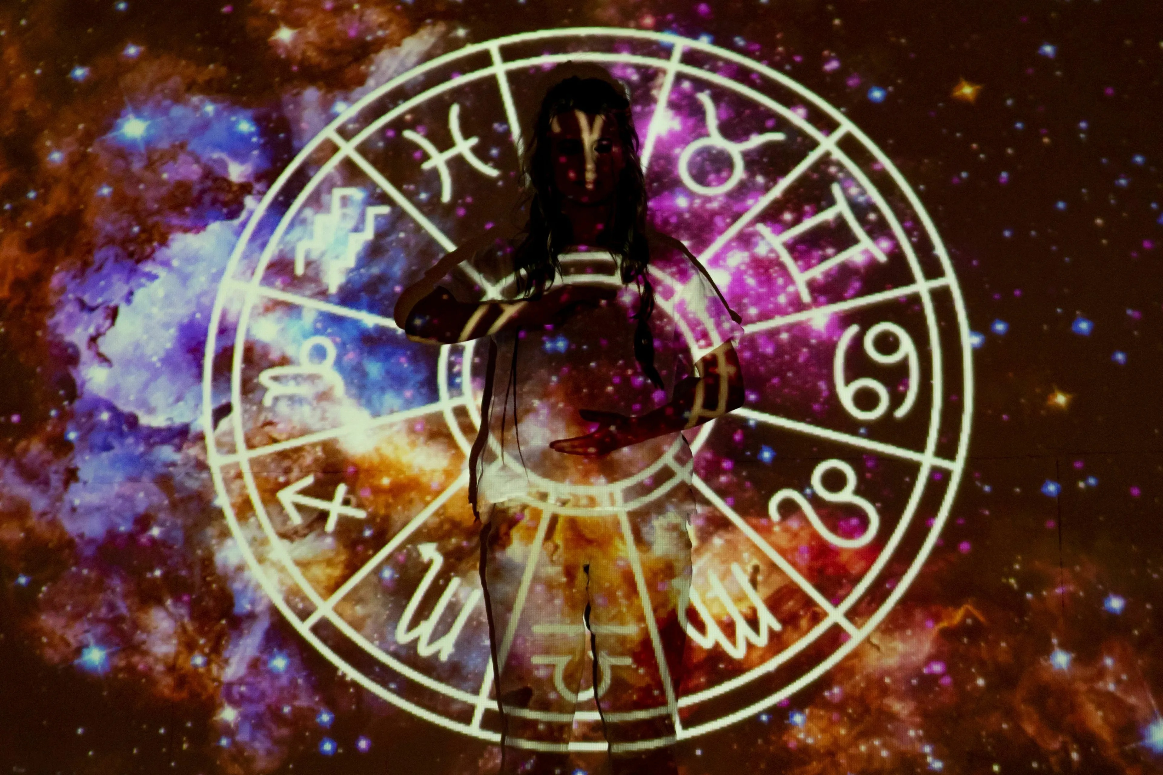 Person with a zodiac horoscope wheel and galaxy overlay, feeling about horoscopes and daily signs.
