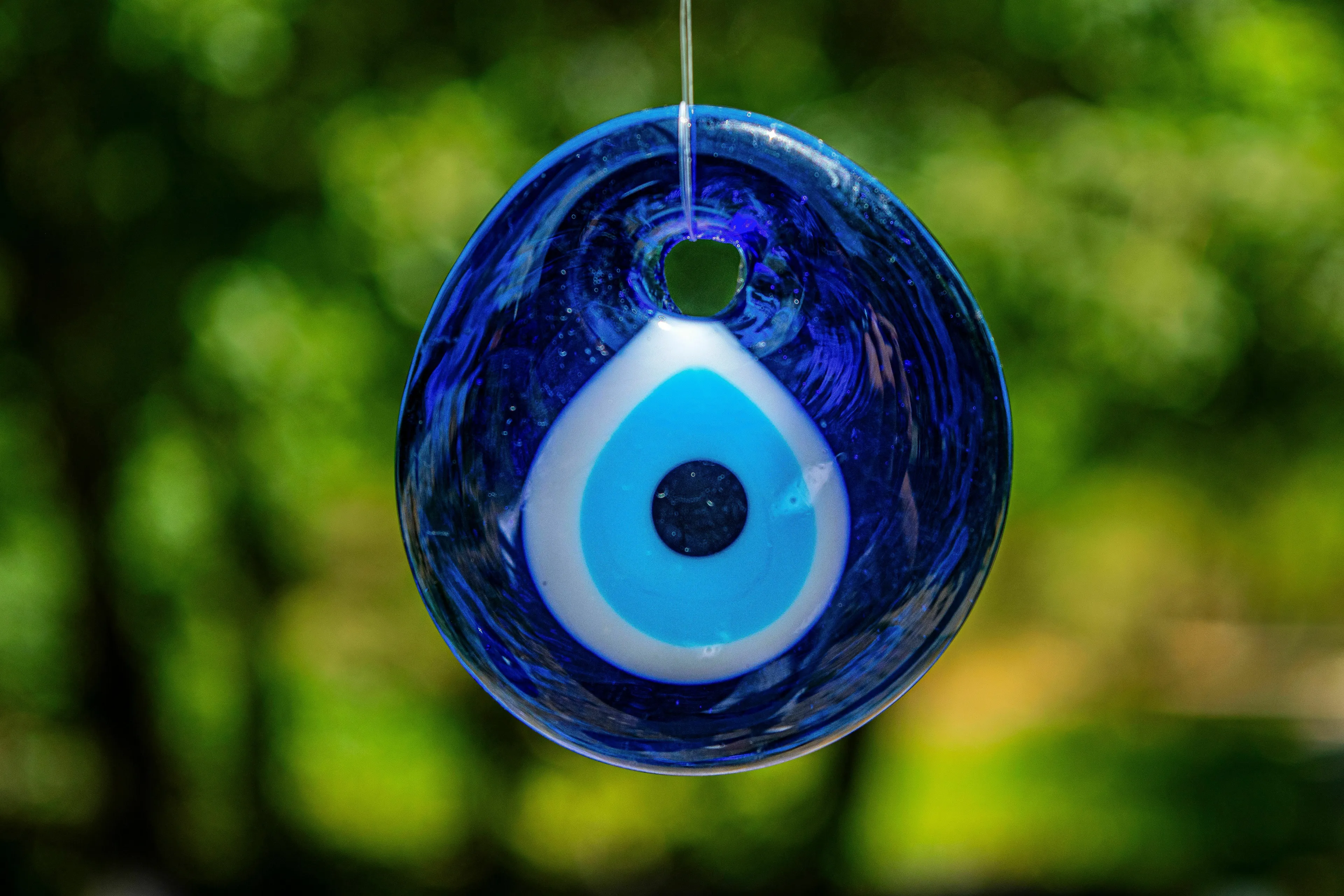 A close-up of a lucky blue evil eye charm, representing a lucky object or routine.