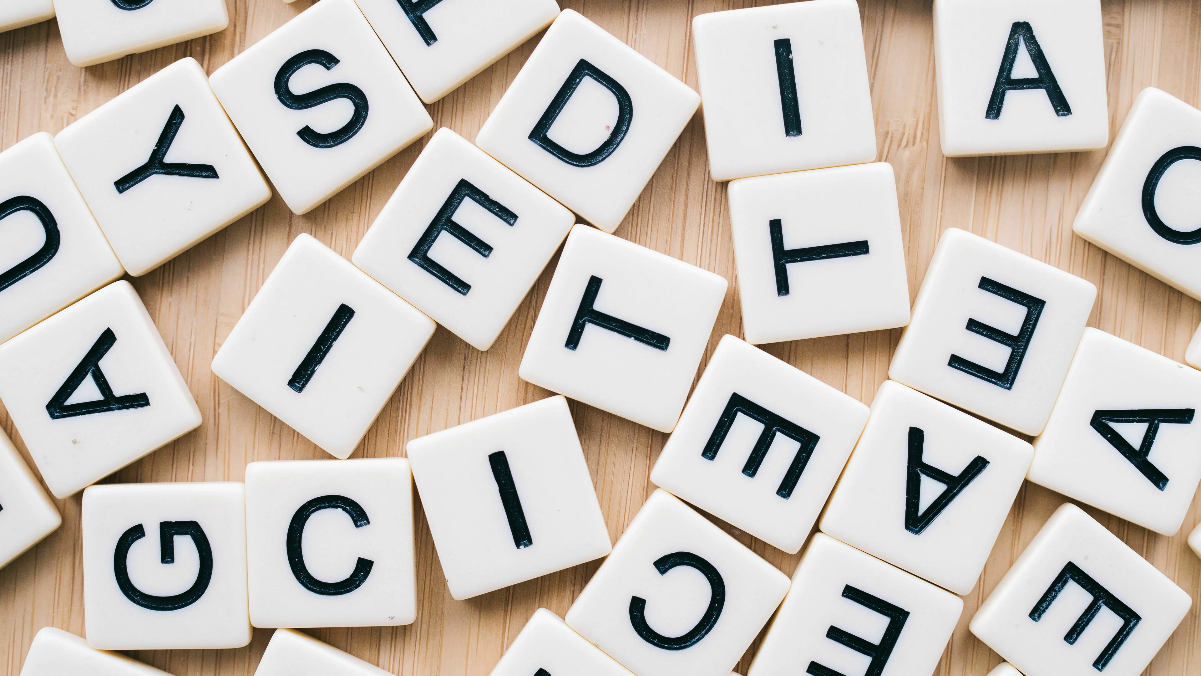 Scattered letter tiles illustrate words made from the first letters of a series of words, like NASA, for a pub quiz.