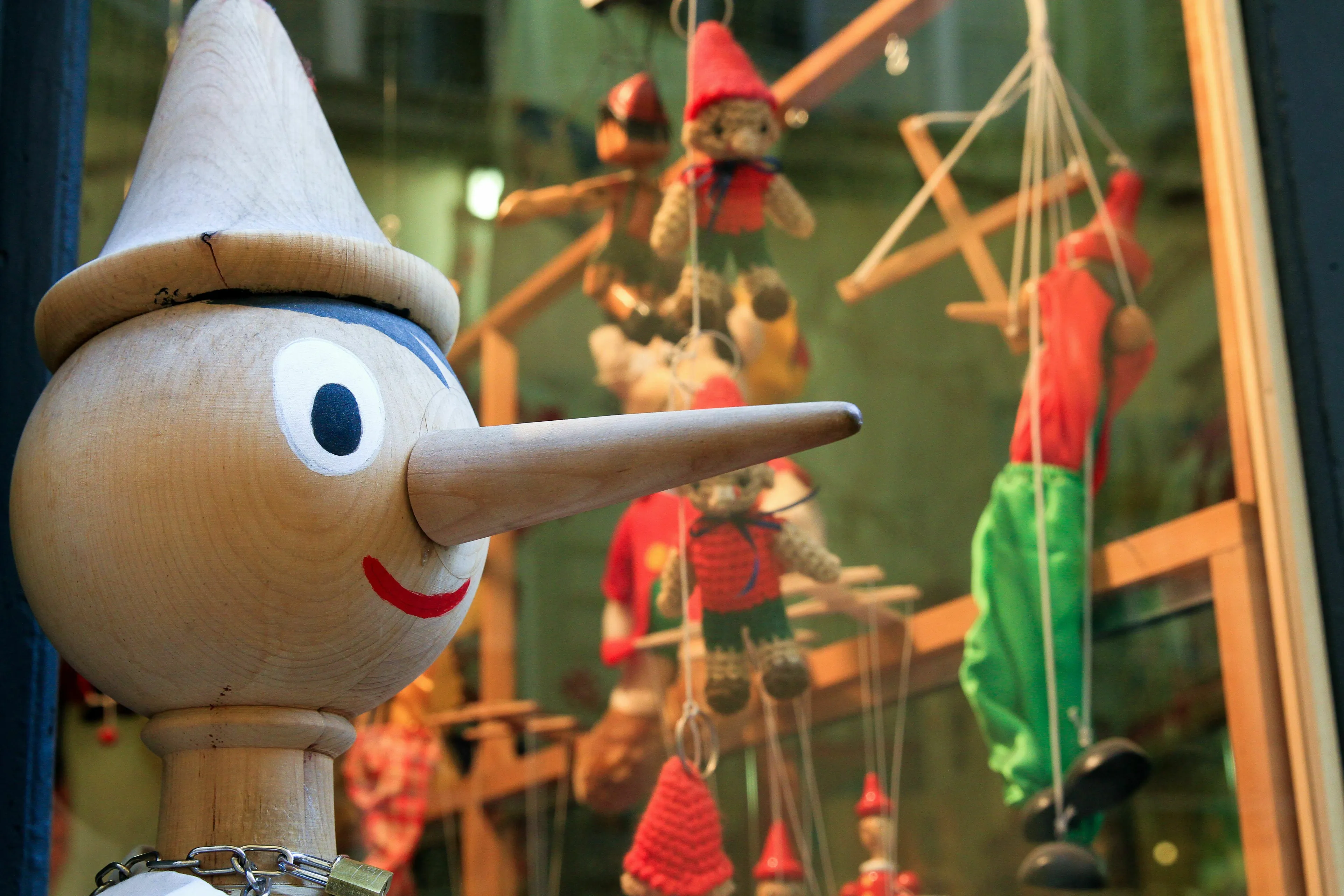 A close-up of a wooden Pinocchio puppet in a window display, a fictional wooden puppet in a pub quiz.