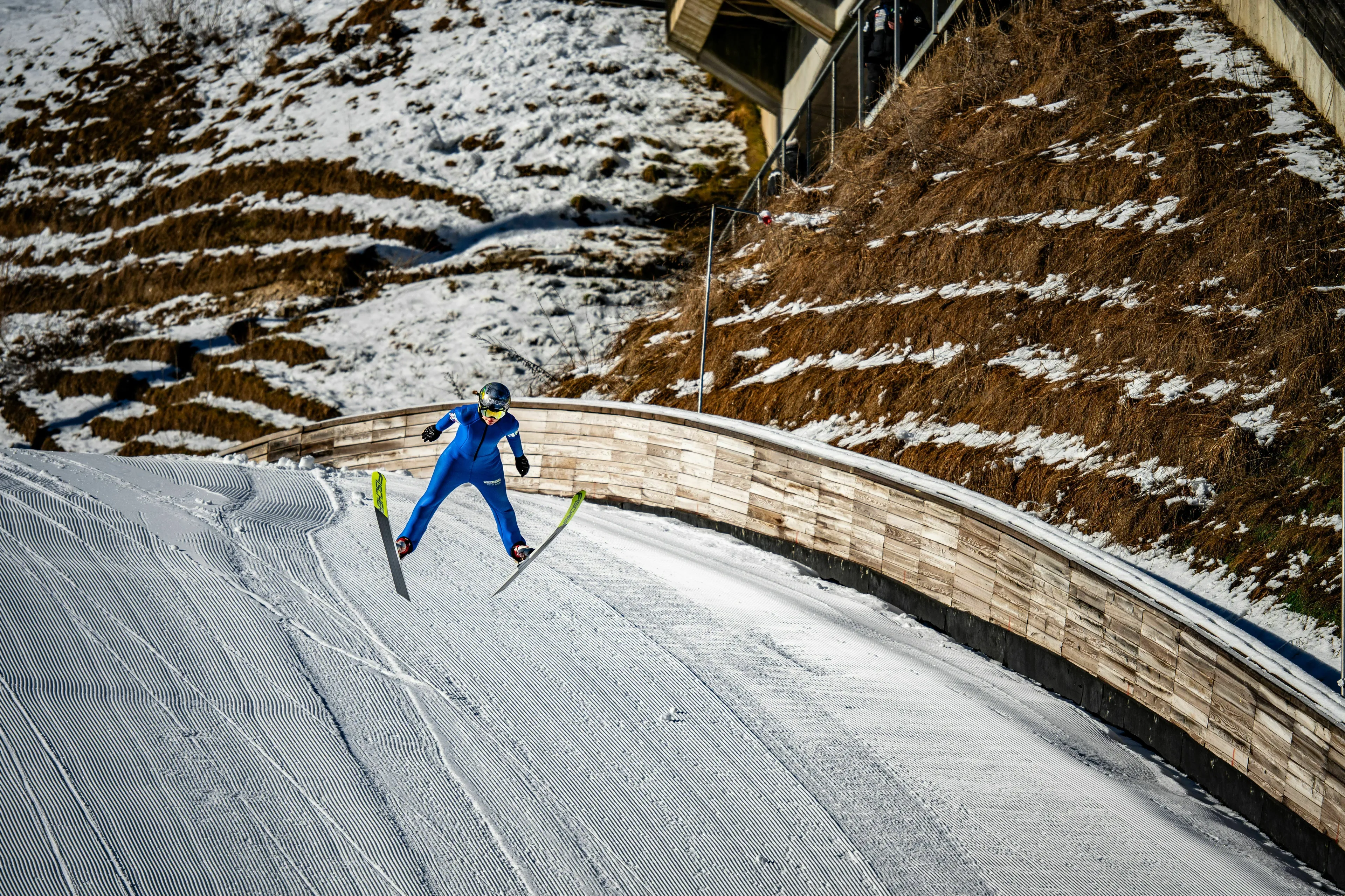 A ski jumper in mid-air performing a winter sport jump during a general knowledge pub quiz.