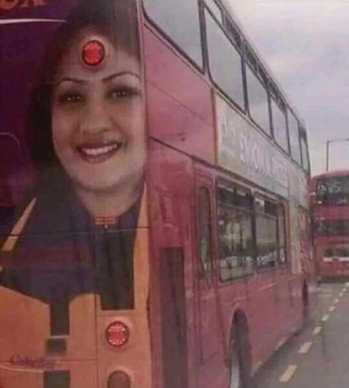 A woman's face on the side of a bus, with bus lights perfectly aligned as her third eye and earrings, creating interesting and hilarious ad placement.