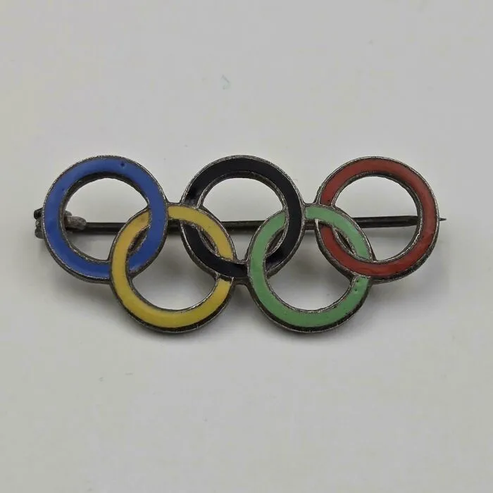 A vintage Olympic rings pin, a rare thrift store jackpot, featuring the iconic interlocking colored rings.
