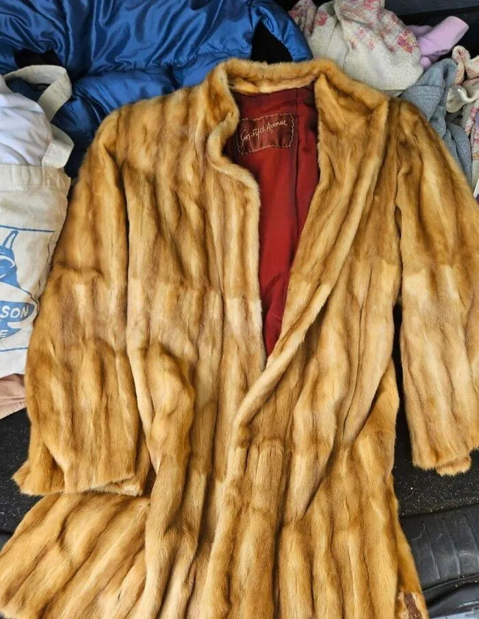 A luxurious long fur coat with a red lining, an incredible fashion jackpot from a thrift store.