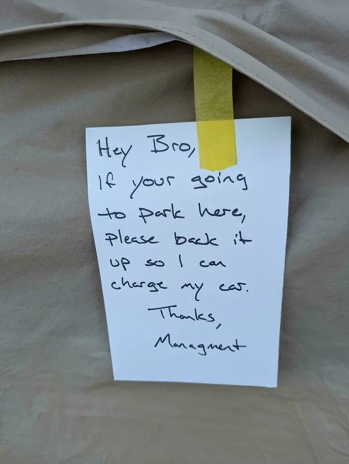 A note taped to a car asking the driver to back up, addressing a common sense parking issue.