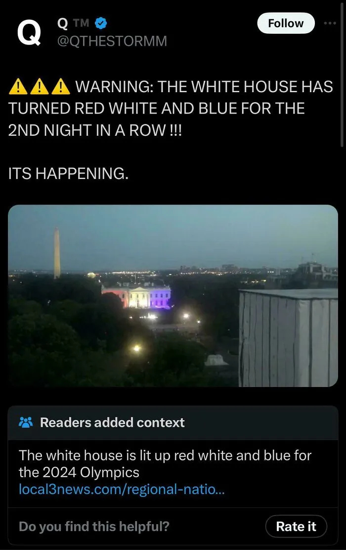 The White House lit up red, white, and blue at night, with a fact-checked note explaining it is for the 2024 Olympics.