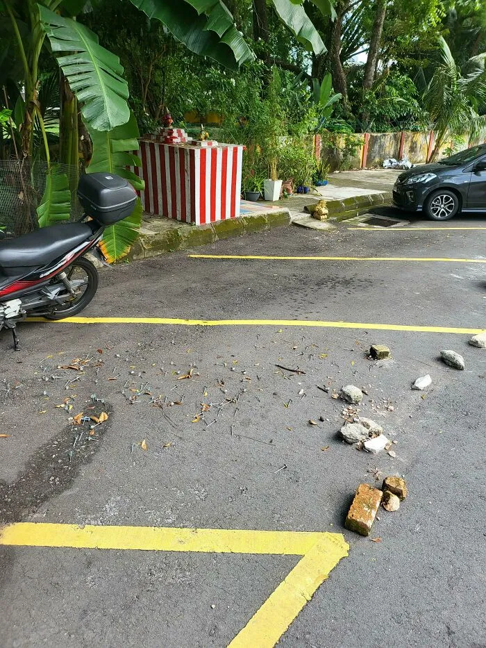 Debris and bricks in a parking spot, indicating a lack of common sense in parking among jerk neighbors.