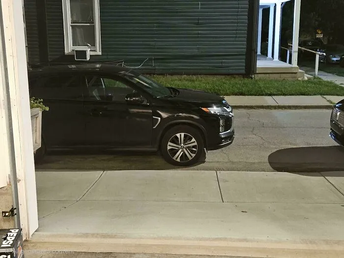 A black car poorly parked, blocking a sidewalk. Neighbors parking badly often lack common sense.