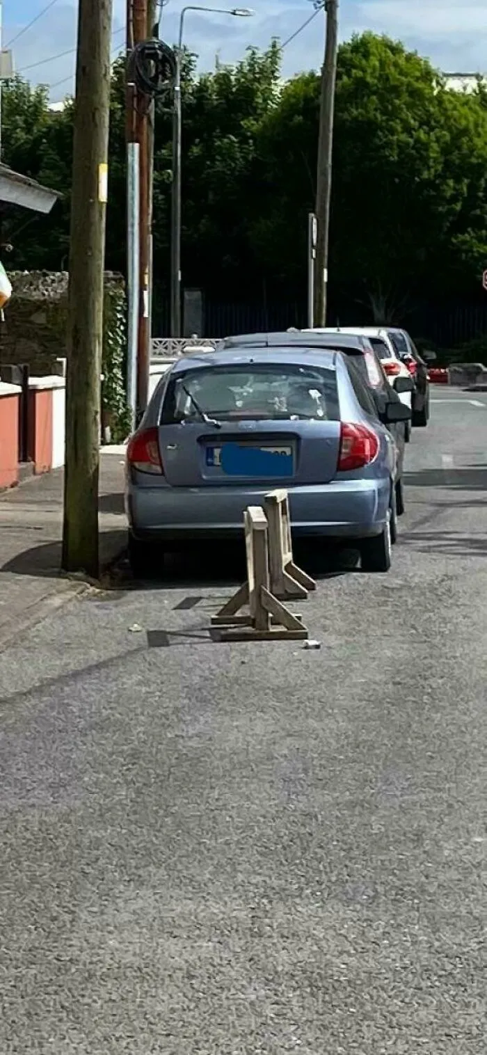 A poorly parked car blocking the pavement, illustrating a common problem with parking and neighbors.