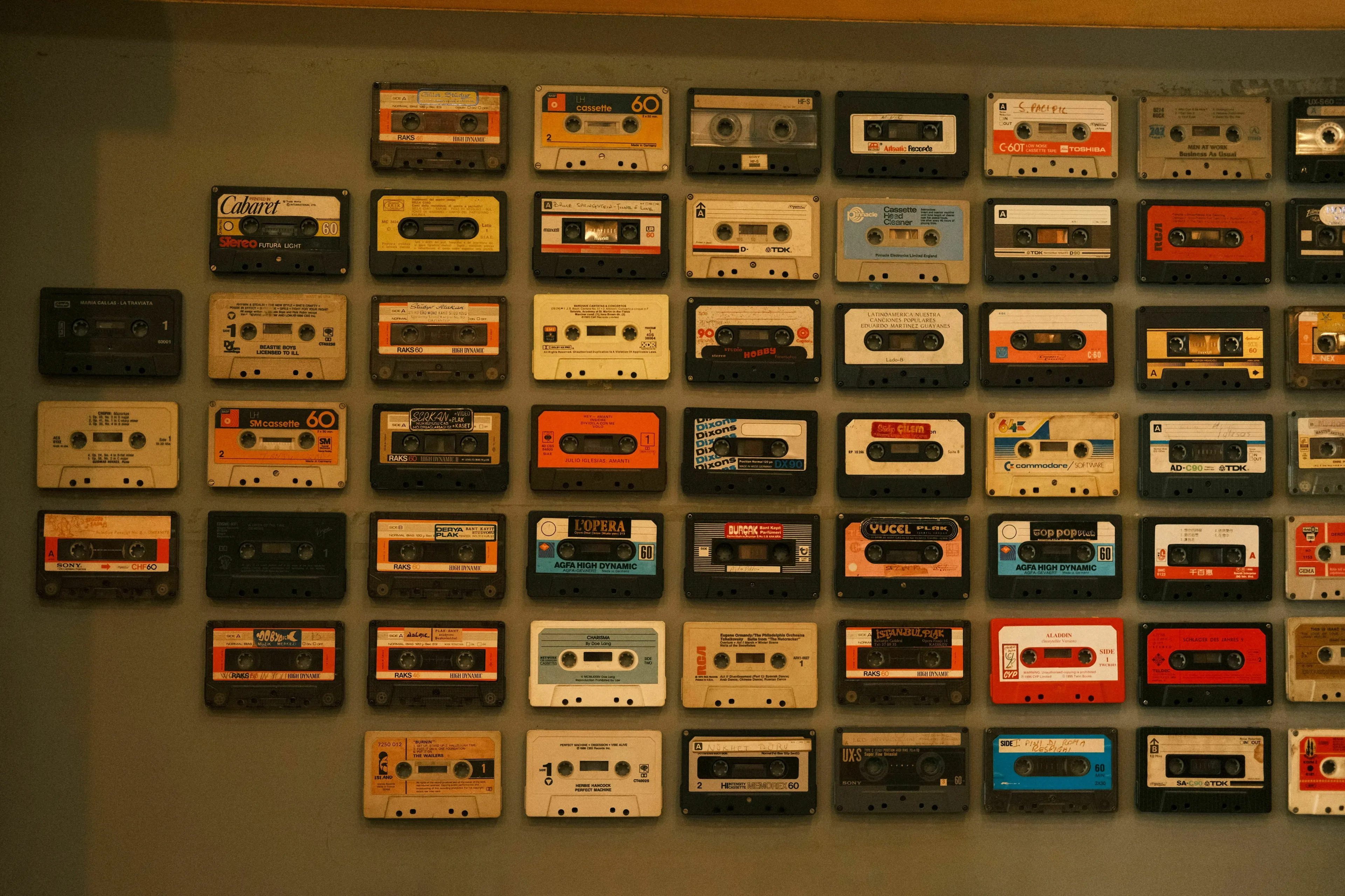 A wall decorated with an array of vintage cassette tapes, representing different decades to explore what kind of liar you are.