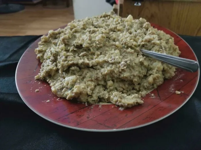 Mashed potato dish with meat mixture on a red plate showing questionable food combos.
