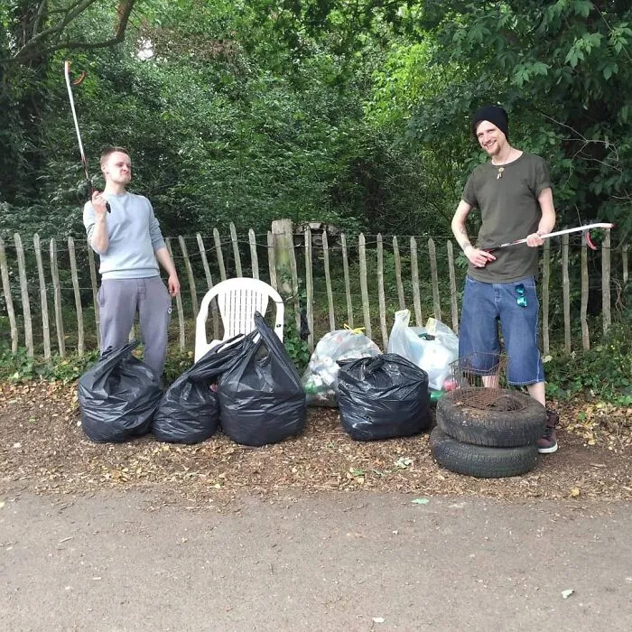 Two young men proud after collecting trash from the forest, becoming influencers for a cleaner world.