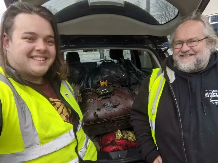 Influencers smiling, with a car trunk full of trash they have removed, advocating against trash taking over the world.