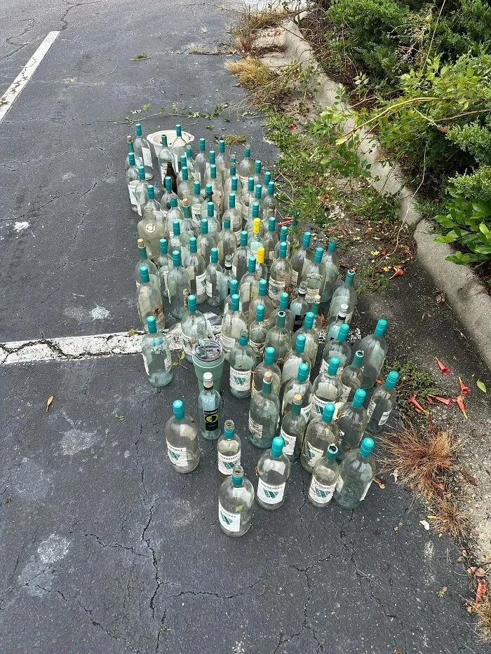 Many empty bottles on an asphalt surface, illustrating the amount of trash that takes over the world.
