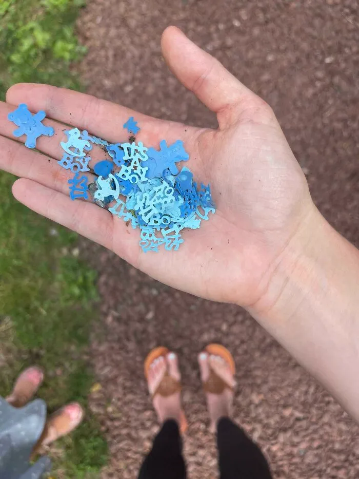A person holding small blue plastic pieces in their hand, representing the tiny bits of trash taking over.