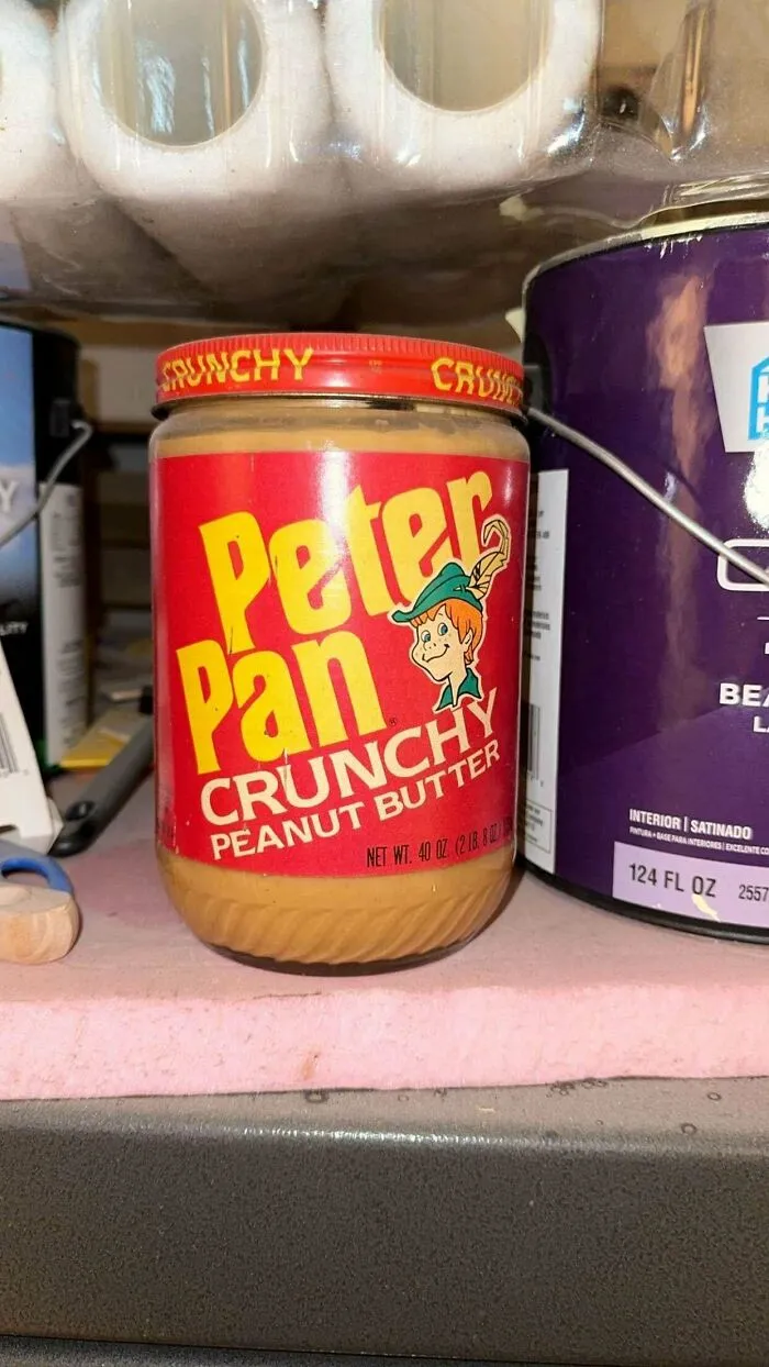 An old jar of Peter Pan Crunchy Peanut Butter, a product found at home that proves some people never throw anything away.