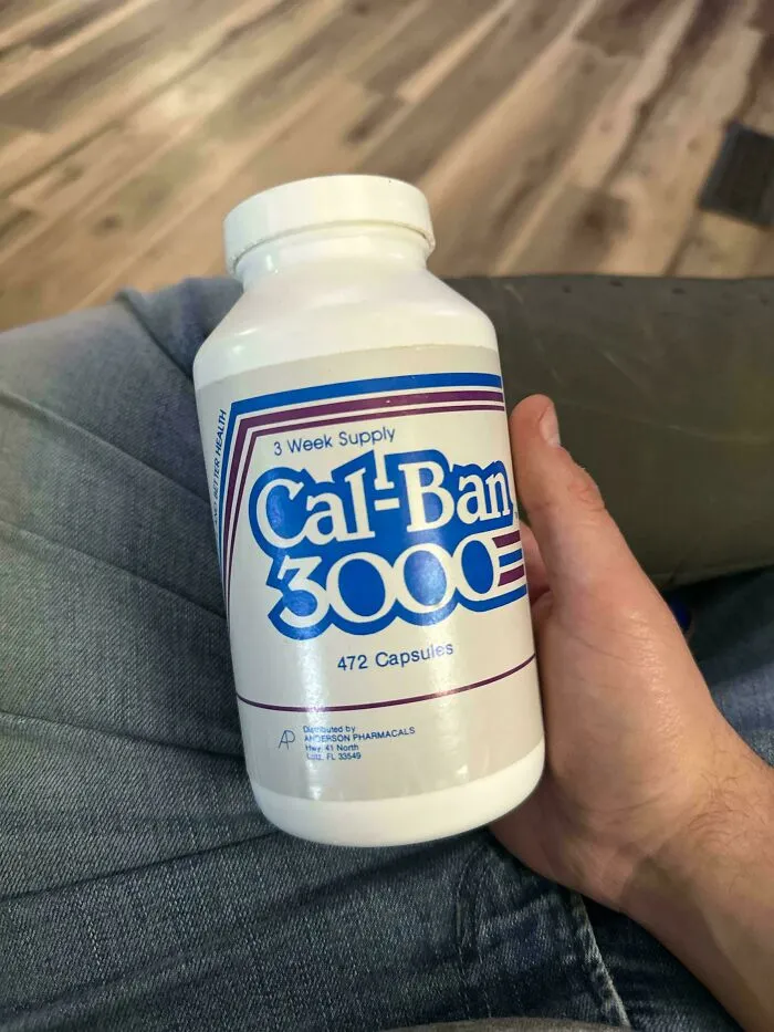A hand holding a white bottle of Cal-Ban 3000 pills, one of the old products people found at home.
