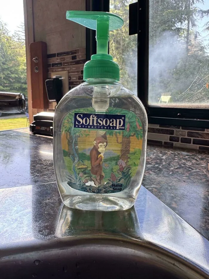 An old bottle of Softsoap antibacterial hand soap with a monkey on the label, an old product found at home.