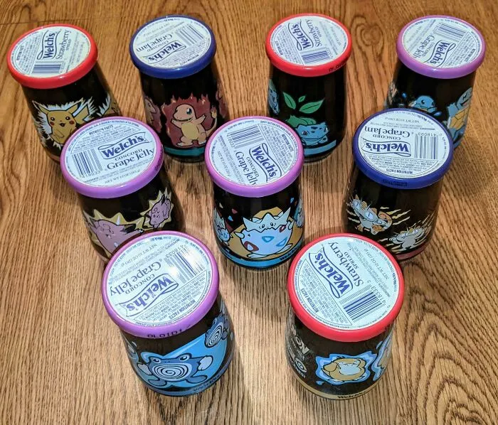 Nine jars of Welch's grape and strawberry jelly, featuring various Pokemon characters, old products found at home.