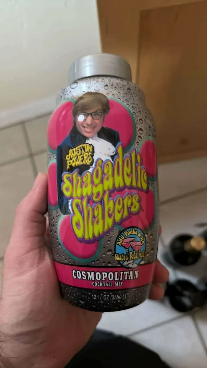 A hand holding an old Austin Powers Shagadelic Shakers cocktail mix bottle, an old product found at home.