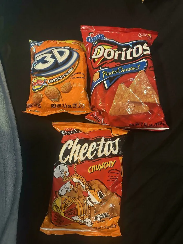 Three bags of old products: Ruffles 3D, Doritos Nacho Cheesier, and Cheetos Crunchy. These old products were found at home.