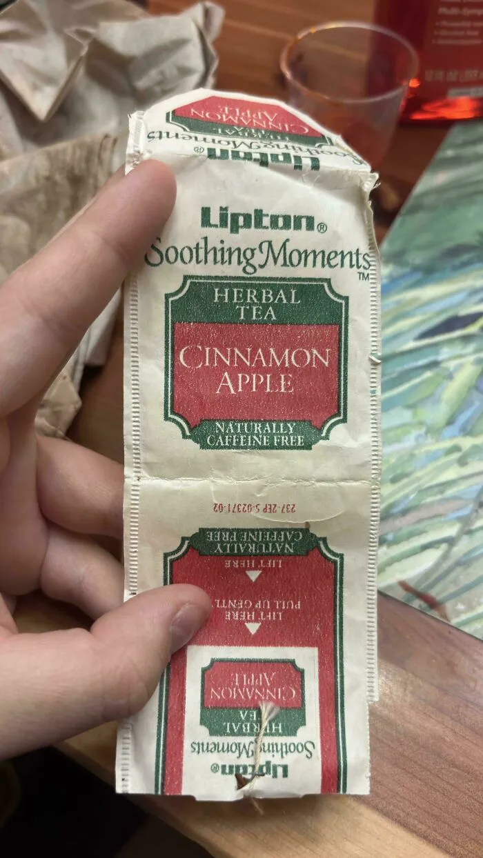 A packet of Lipton Soothing Moments Cinnamon Apple Herbal Tea, an old product found at home.