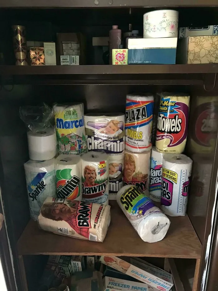 A closet shelf filled with various rolls of old paper towels, an example of old products people found.