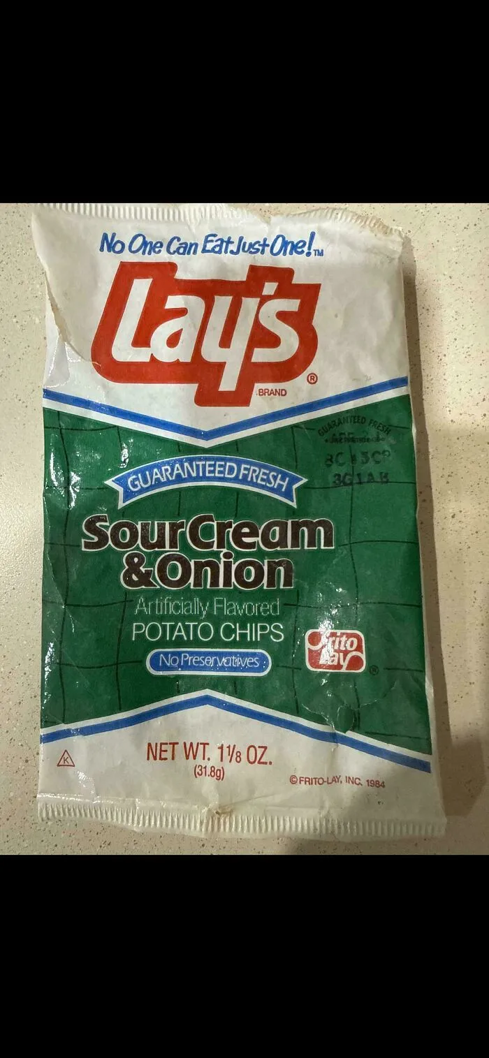An old, unopened bag of Lay's Sour Cream & Onion potato chips from 1984, an old product found at home.